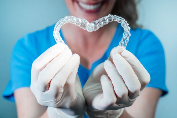 Dentist holding tooth model explaining dental care