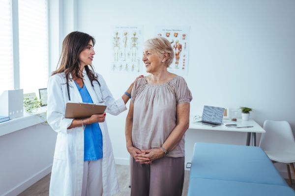 Doctor assisting elderly woman