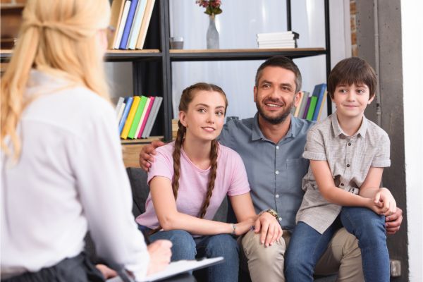 family attending therapy session with therapist