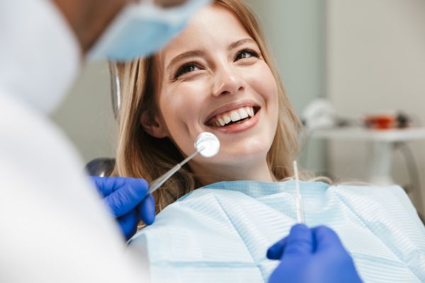 Female dentist smiling with patient during dental checkup