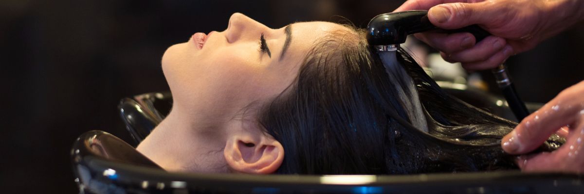 Woman getting hair washed at salon — local SEO for hairdressers