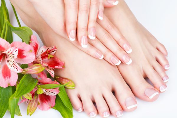 Client receiving manicure and pedicure at beauty salon