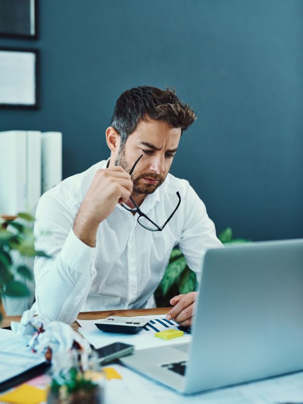 Accountant working on laptop with financial documents
