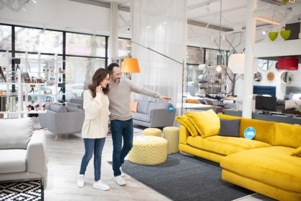 Couple choosing a sofa in a modern furniture store