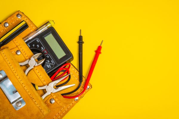 electrician testing equipment and tools on yellow background