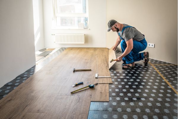 Worker installing new flooring during home renovation project
