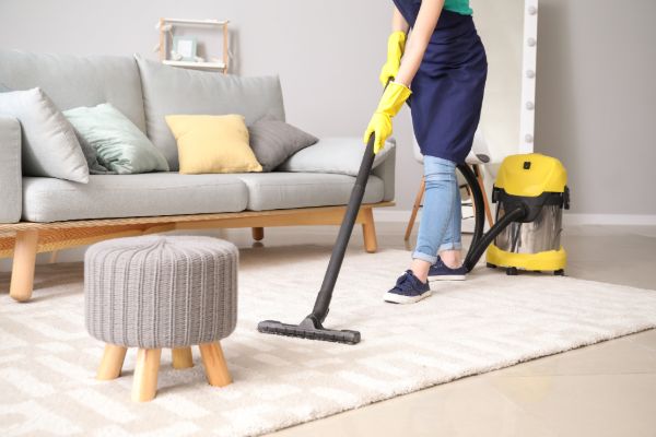 Person vacuuming carpet in living room
