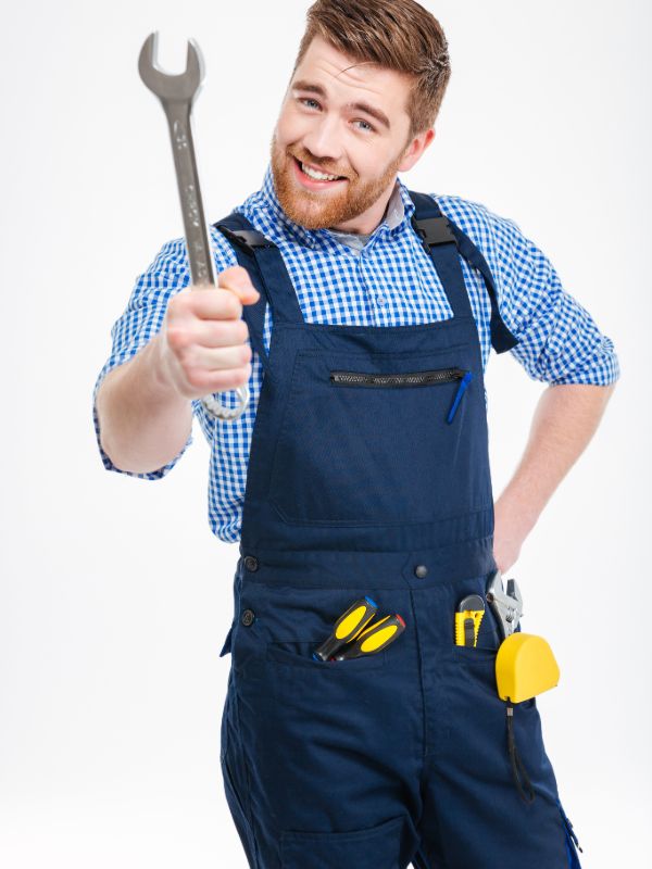Professional plumber holding wrench and tools