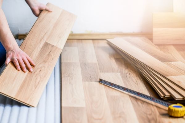 Worker installing wooden flooring during home interior improvement