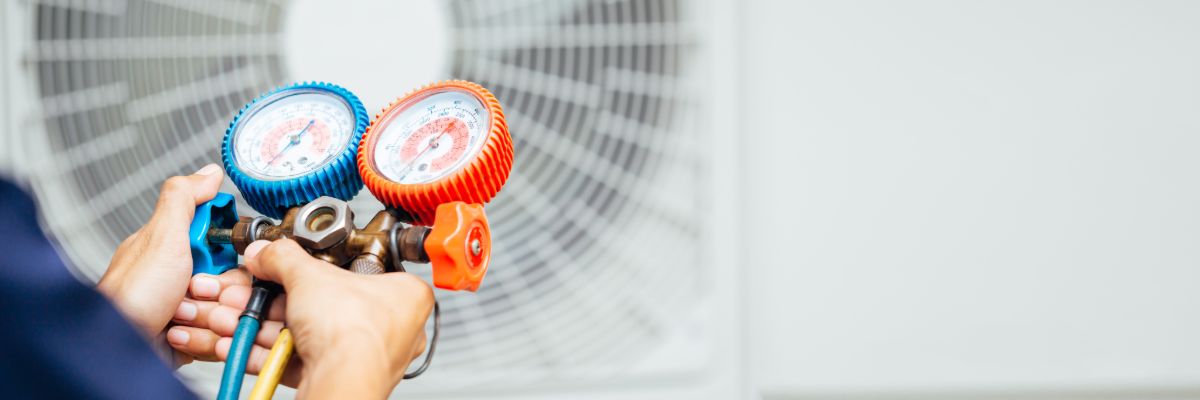 Technician checking air conditioning system pressure during a diagnostic inspection