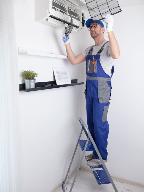 Technician installing an indoor air conditioning system in a residential property