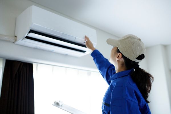 Technician servicing a wall-mounted air conditioner