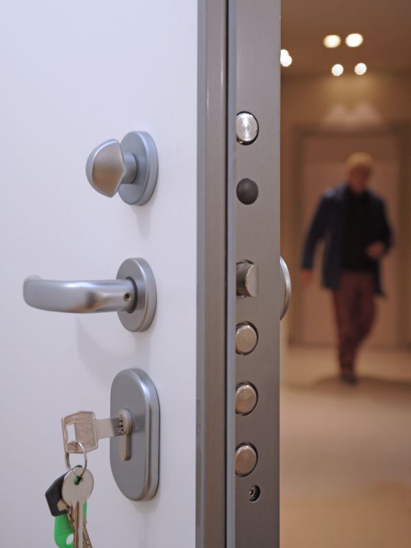 Close-up of a door lock with a person in the background