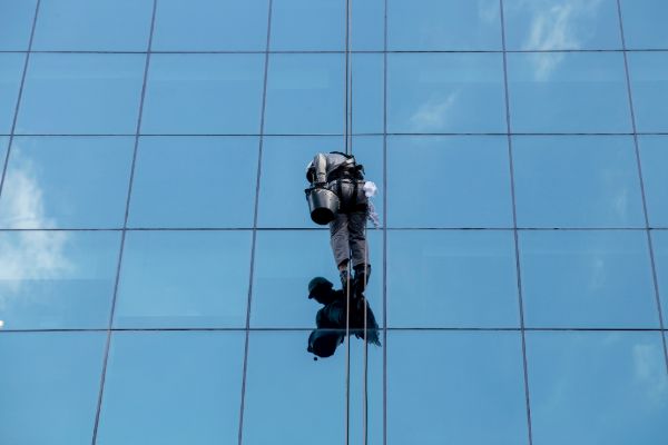 High-rise window cleaner working on a modern glass building exterior