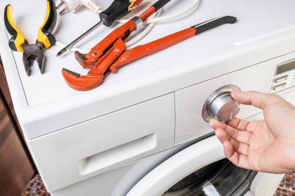 Handyman repairing a household washing machine appliance