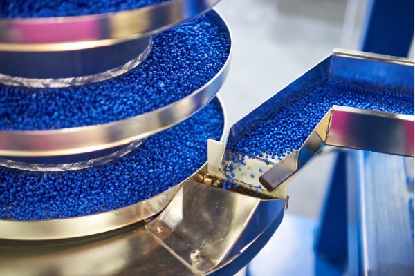 Industrial machine sorting blue raw materials in manufacturing process