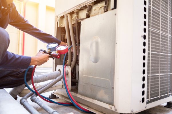 HVAC technician repairing an outdoor air conditioning condenser unit