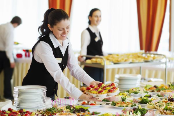 Professional catering staff arranging buffet food for guests