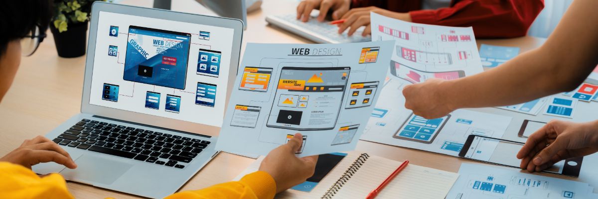 Team reviewing website layout designs on a laptop