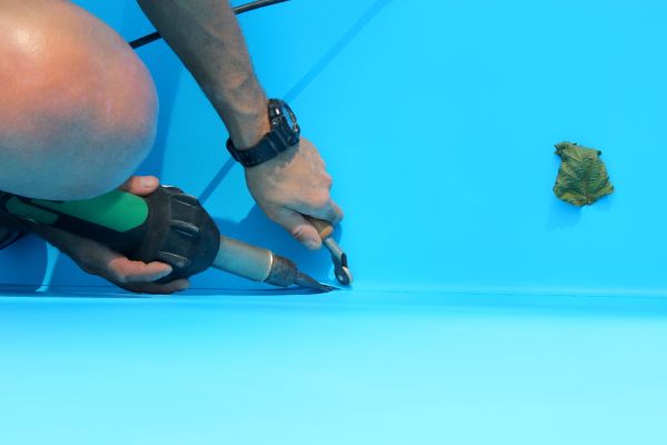 Swimming pool technician performing underwater pool repair