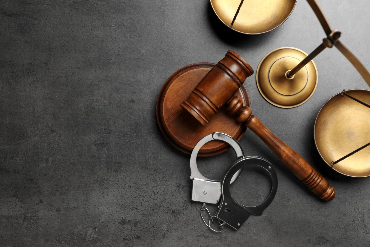 Criminal defense law concept with judge gavel, scales of justice, and handcuffs